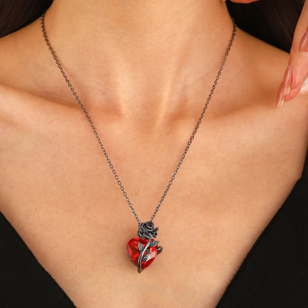 Gothic rose anatomy heart pendant necklace featuring a crimson red heart and dark rose accents on a chain, worn on a model.