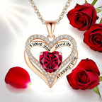 Sculpted rose gold heart pendant necklace with a large red gemstone, surrounded by sparkling accents, and rose petals.