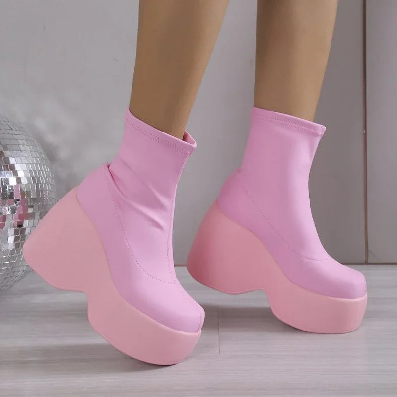 Chunky platform boots in vibrant pink, featuring a snug sock-like fit and sleek rubber base, ideal for bold streetwear looks.