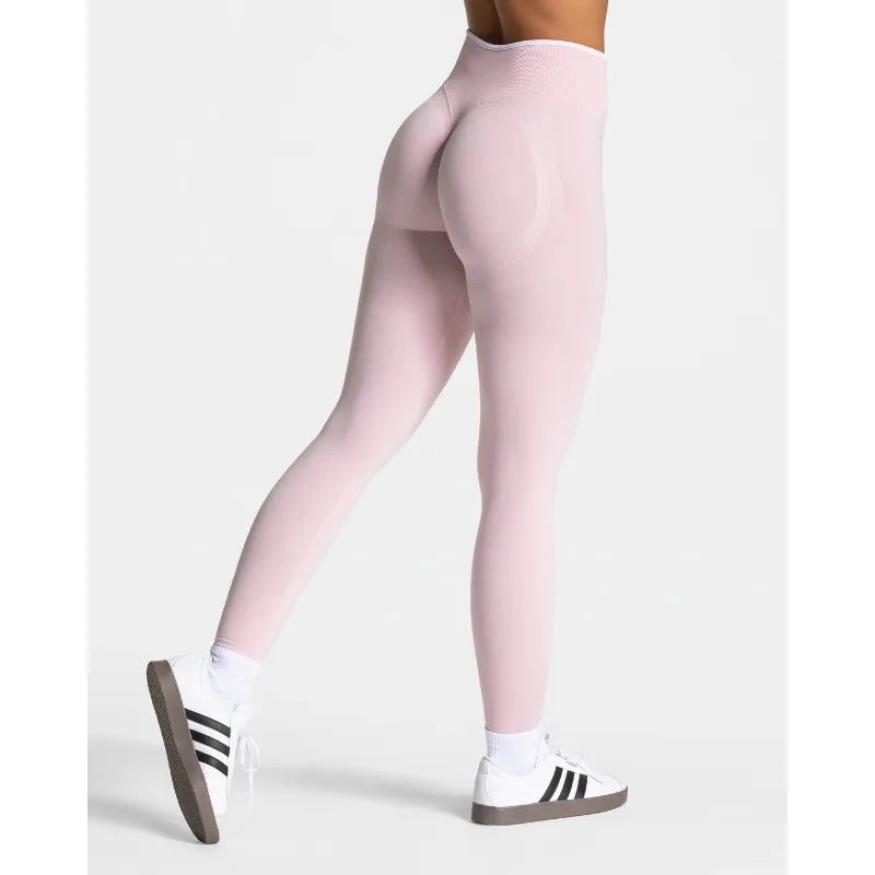 High-waisted, seamless leggings in soft pink with a form-fitting silhouette, paired with white sneakers.