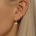 Three-piece earring set featuring gold hoop earrings, a star-shaped drop earring, and a small star stud with sparkly accents.
