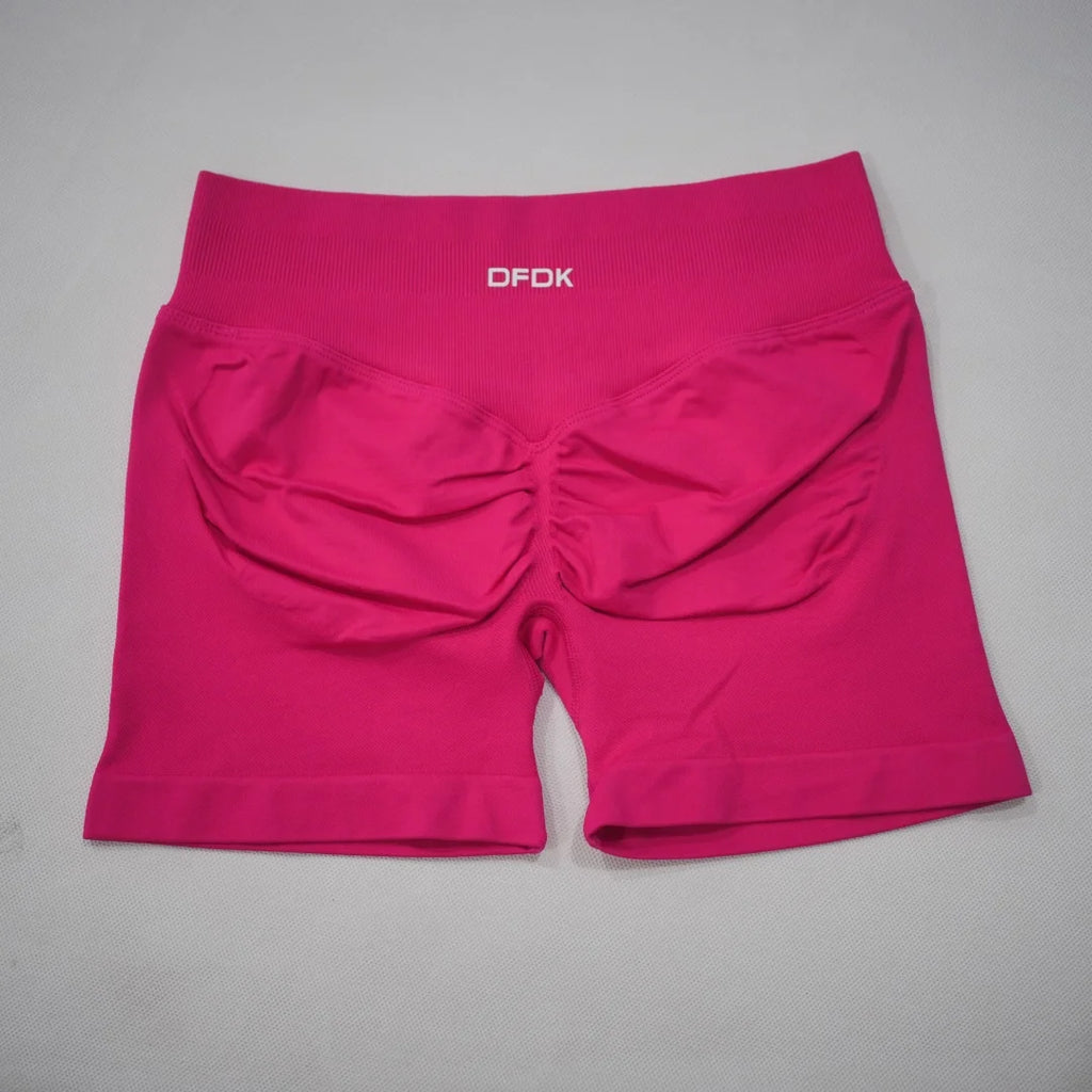 High-waisted gym shorts in a vibrant pink color with a scrunch design and supportive waistband. Lightweight, seamless fit.