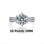 Round-cut Moissanite stone in a 925 sterling silver band, accented by smaller stones on the sides, showcasing high polish.