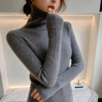 Slim-fit turtleneck in soft gray cashmere, featuring ribbed texture and extended sleeves, styled elegantly with a high neck.