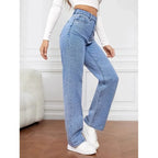 High-waisted wide-leg denim jeans in light blue, featuring a tailored fit and paired with white sneakers and a cropped top.