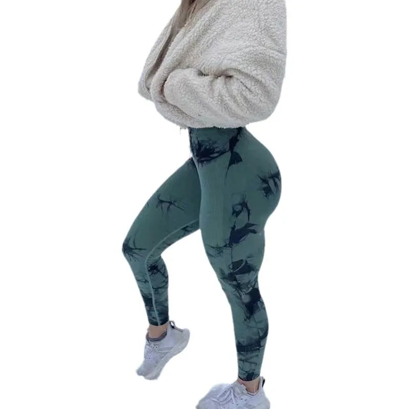 High-waisted green tie-dye leggings with scrunch detail, paired with a cozy white cropped fleece and white sneakers.
