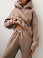 Cozy beige high-waisted joggers and oversized hoodie set, featuring a relaxed fit and soft fleece material.
