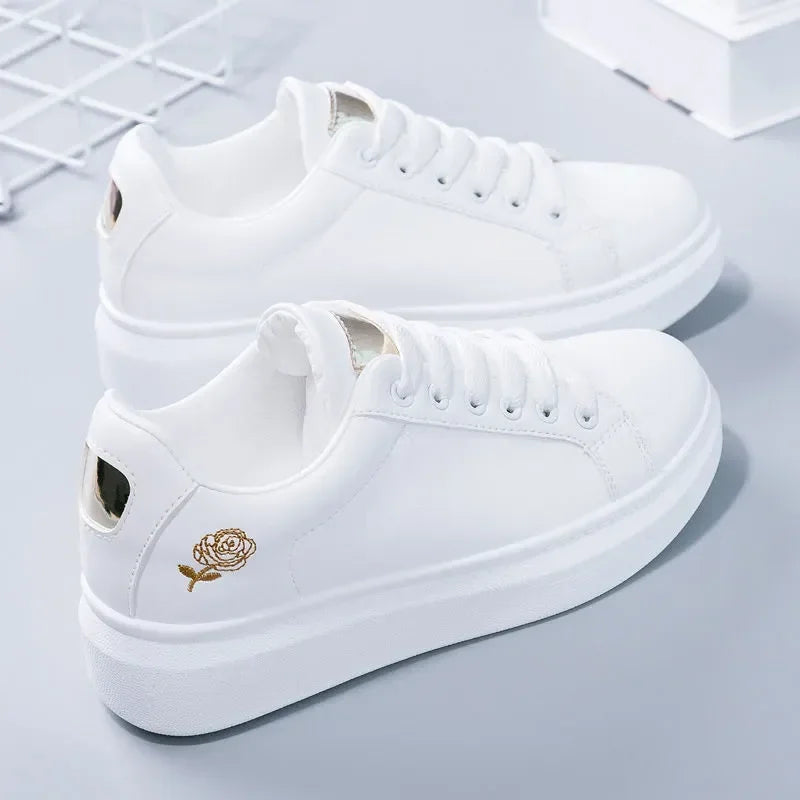 White premium sneakers featuring delicate gold floral embroidery, lightweight design, and secure lace-up closure.