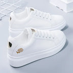 White premium sneakers featuring delicate gold floral embroidery, lightweight design, and secure lace-up closure.