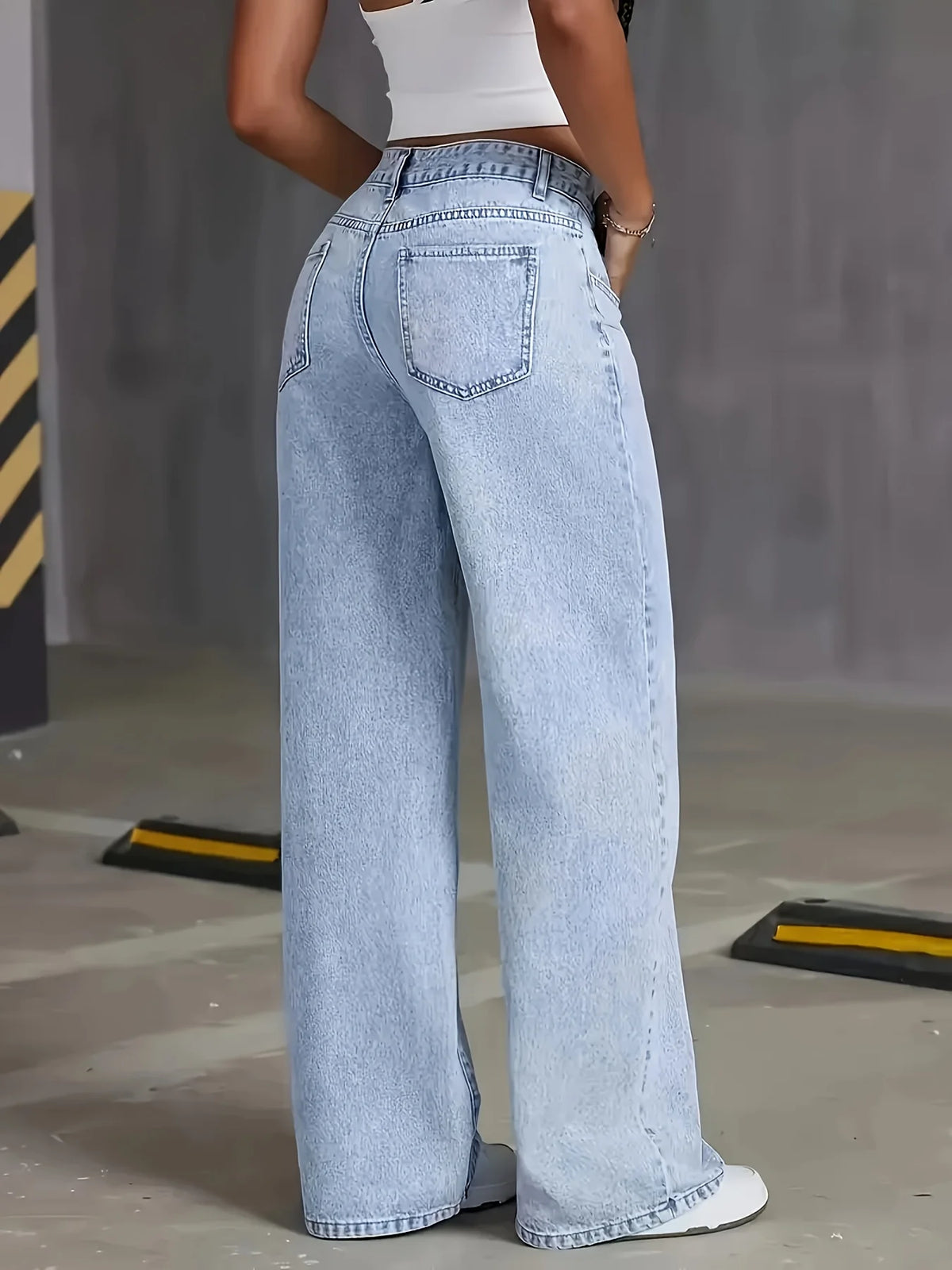 Light wash high-waisted wide-leg denim jeans with a relaxed fit and traditional pockets, styled with a fitted top.