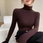 Slim-fit turtleneck sweater in rich brown cashmere, featuring ribbed texture and a high neck, styled with tailored pants.