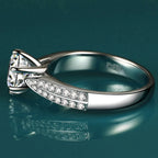 Round-cut Moissanite ring in high-polish 925 sterling silver, features side stone accents for added sparkle.