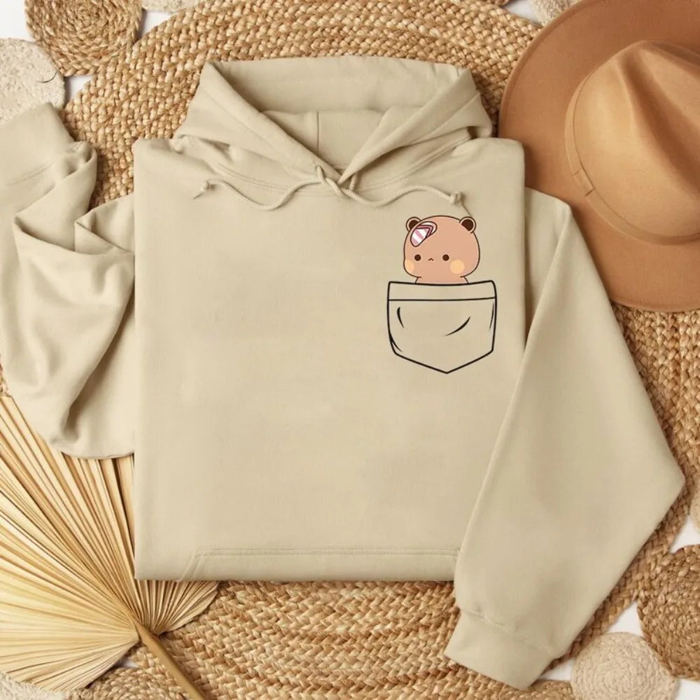 Beige oversized hoodie featuring a cartoon bear in a pocket design, made from soft cotton-fleece material.