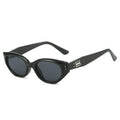 Chunky cat-eye sunglasses with a glossy black finish and dark lenses, featuring a bold, sculpted silhouette.