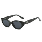 Chunky cat-eye sunglasses with a glossy black finish and dark lenses, featuring a bold, sculpted silhouette.