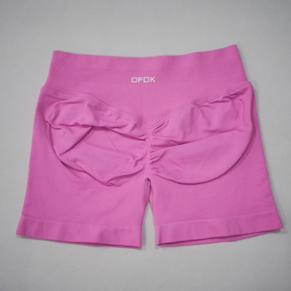 High-waisted gym shorts in bright pink, featuring a scrunch-butt design and wide elastic waistband for support.