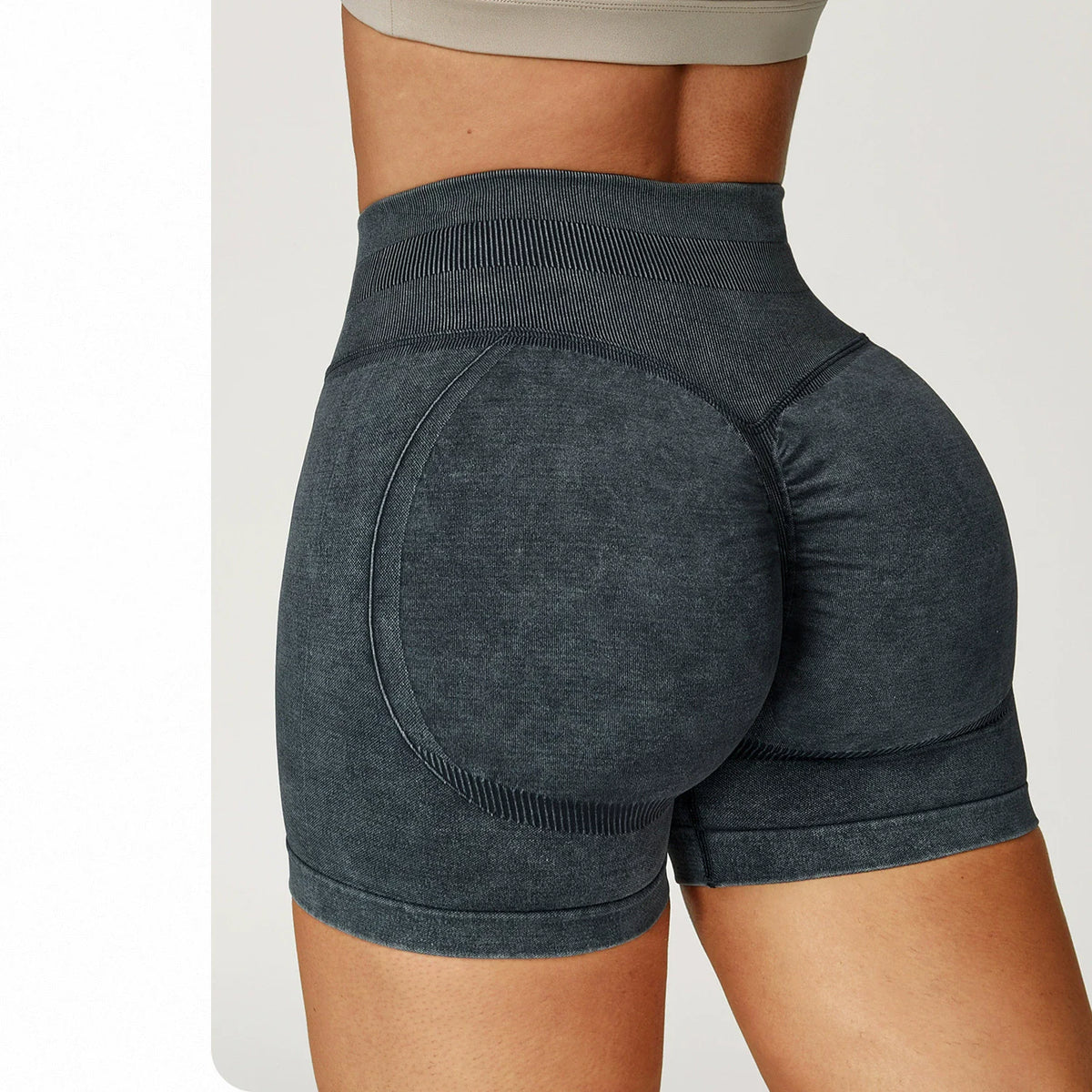 High-waisted dark gray seamless gym shorts with a sand-washed texture, featuring a sculpting fit and subtle rear lift.