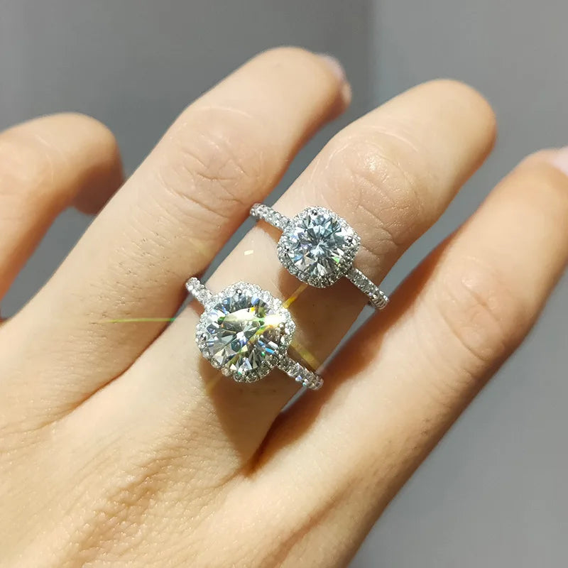 Sparkling LOVORA™ Aura Luxury Halo Moissanite Statement Rings on fingers, featuring round-cut center stones and halo designs.