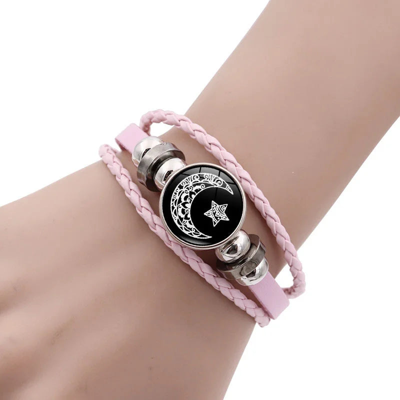 Multi-layered leather bracelet set featuring braided pink cords and decorative moon and star tokens.
