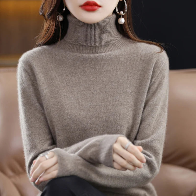 Premium Merino wool and cashmere turtleneck sweater in soft beige, featuring a high collar and ribbed trims, worn casually.