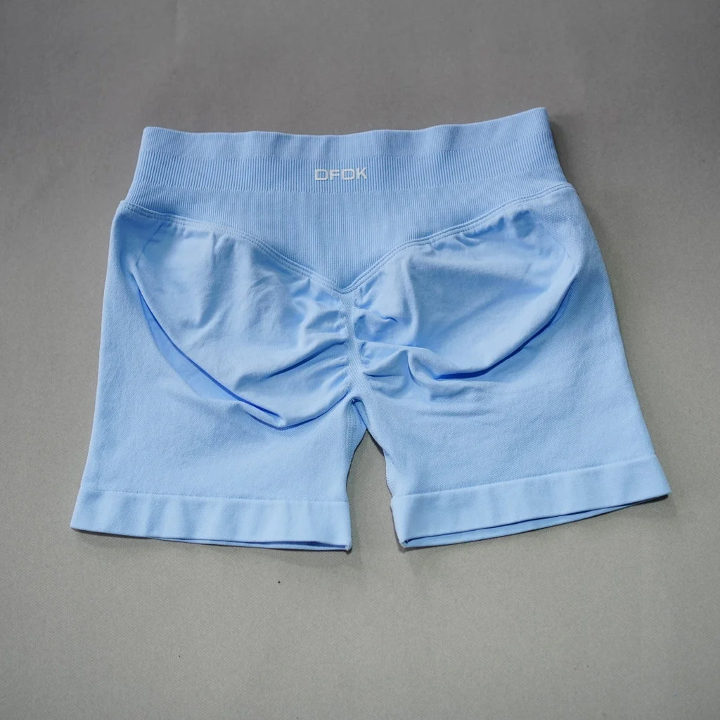 Light blue seamless high-waisted gym shorts featuring a scrunch butt design and wide waistband for added support.