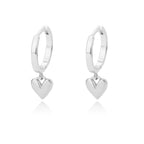 Chunky huggie earrings in polished stainless steel, featuring a dangling heart charm for a minimalist, modern look.