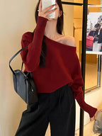 Burgundy LOVORA™ Off-Shoulder Batwing Knit Premium Pullover with relaxed batwing sleeves, worn off one shoulder, styled with black pants.