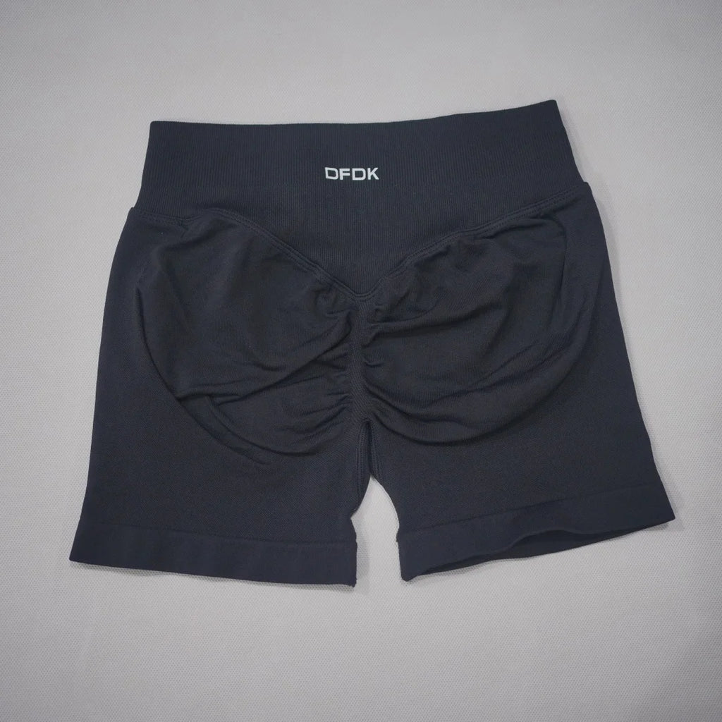 High-waisted black gym shorts with a scrunch-butt design and wide waistband, made from seamless knit fabric.