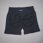High-waisted black gym shorts with a scrunch-butt design and wide waistband, made from seamless knit fabric.