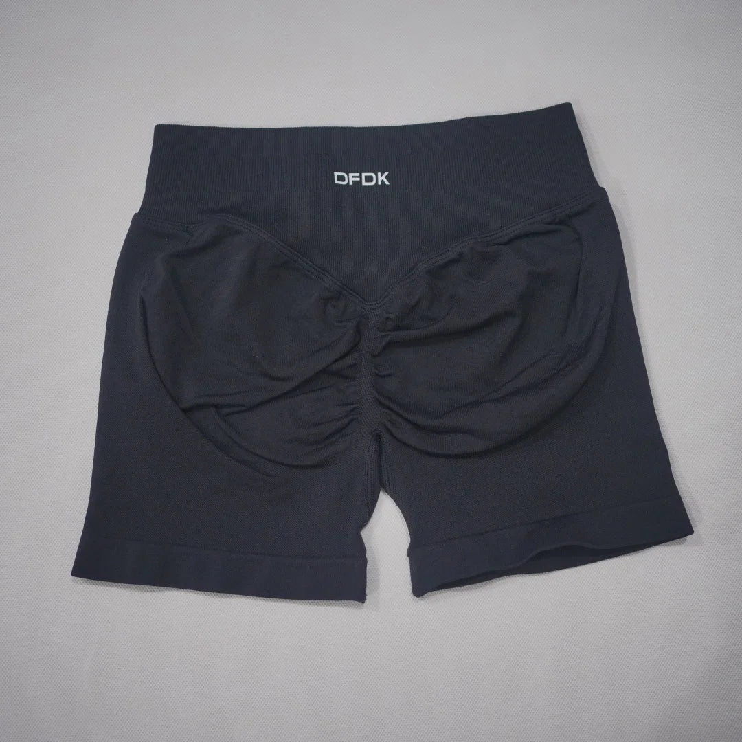 High-waisted black gym shorts with a scrunch-butt design and wide waistband, made from seamless knit fabric.