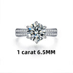 Round-cut moissanite stone set in a high-polish 925 sterling silver band with accent stones on the sides.