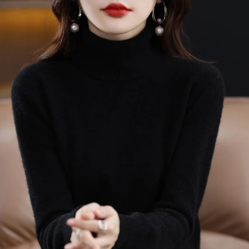 Black turtleneck sweater made from merino wool and cashmere, featuring a relaxed fit and ribbed cuffs, worn with bold earrings.