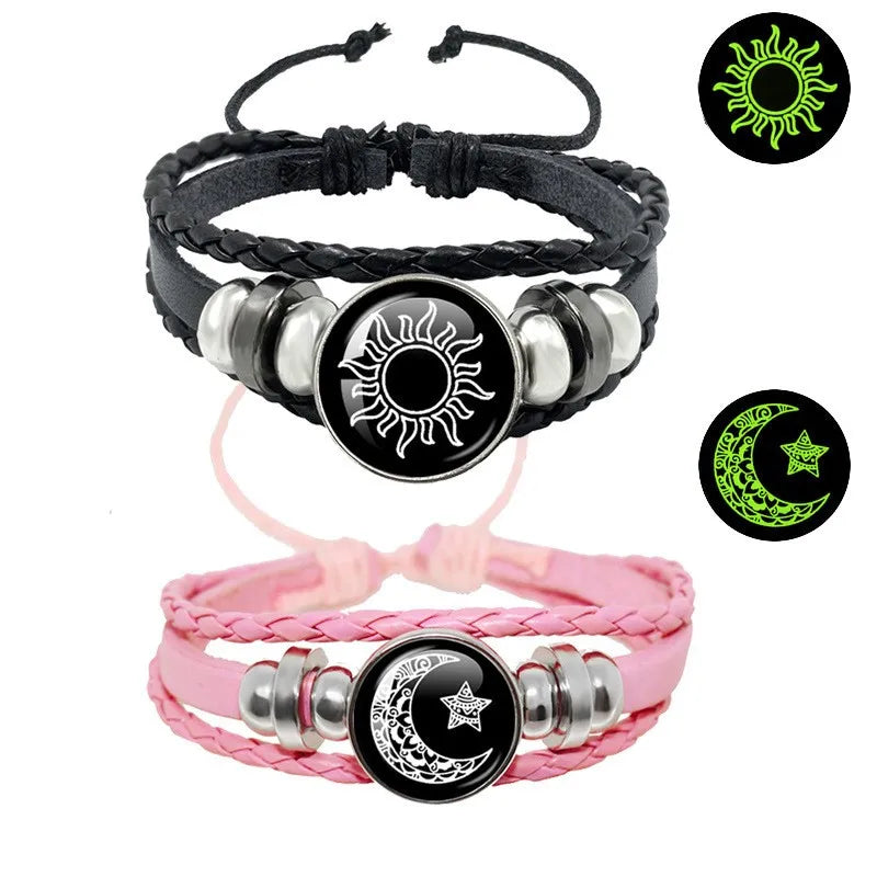 Multi-layered leather bracelet set featuring a black sun design and a pink moon design with braided straps and metal accents.