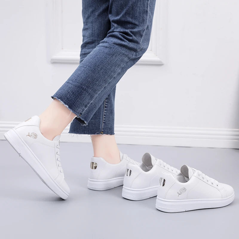 White LOVORA™ Blossom Sneakers with floral embroidery, worn with cropped blue denim. Features lace-up design and low profile.