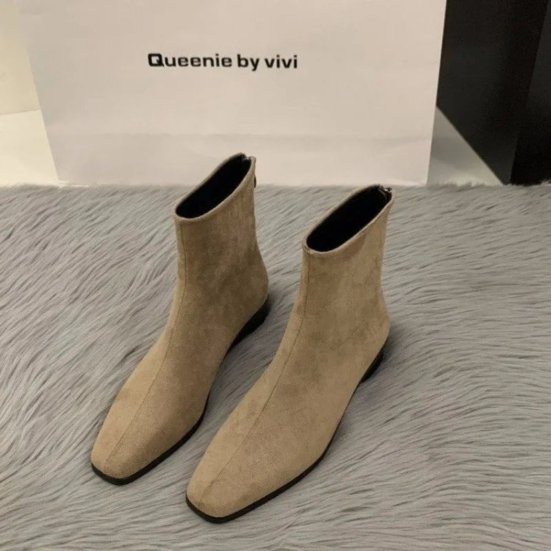 Beige LOVORA™ Premium Suede Back-Zipper Ankle Boots with a sleek design, low-profile block heel, and smooth contours.