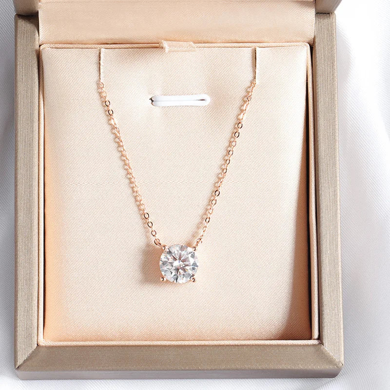 Round-cut Moissanite pendant necklace in rose gold, set in a minimalist crown vault, presented on a delicate chain.