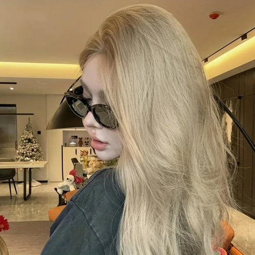 Chunky black cat-eye sunglasses with a glossy finish, worn by a model with long, wavy blonde hair.