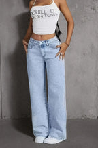 Light wash, high-waisted, wide-leg denim jeans with a relaxed fit, worn with a cropped white top.
