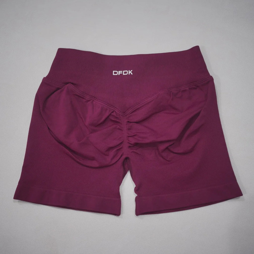 Burgundy high-waisted gym shorts featuring a seamless design and scrunch-butt detail for a flattering fit.