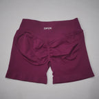 Burgundy high-waisted gym shorts featuring a seamless design and scrunch-butt detail for a flattering fit.